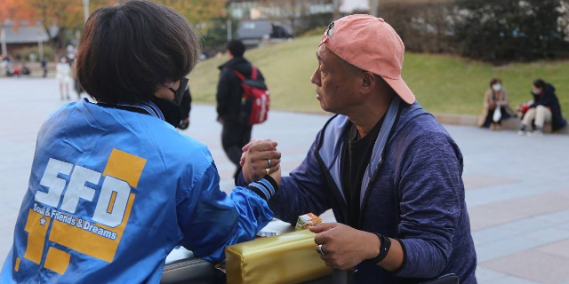 警固公園で「アームレスリング」体験会を開く小野本さん（写真提供：SFD21JAPAN）